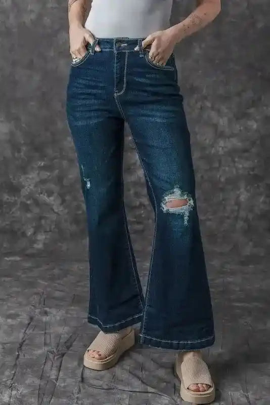 Model posing in Ripped Bell Bottom Jeans with hands in pockets, showcasing the relaxed fit and distressed detailing.