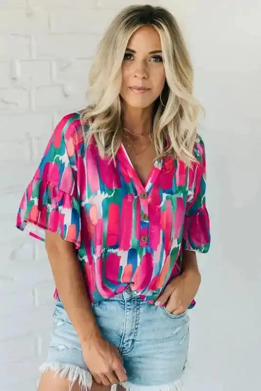 Model wearing Rose Abstract Brushwork Print Blouse tucked into light denim shorts, emphasizing the blouse's colorful and artistic design.