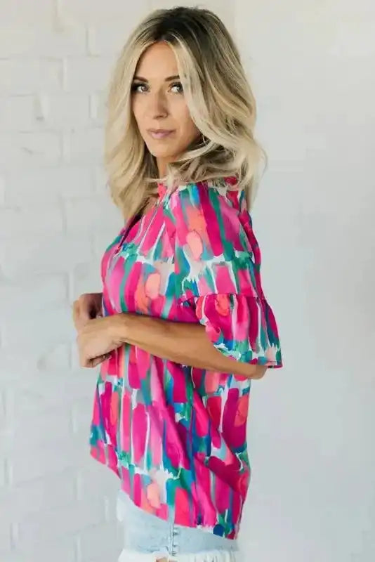 Side angle of Elegant Rose Print Blouse showing off the vibrant abstract pattern and soft ruffle sleeve accents.