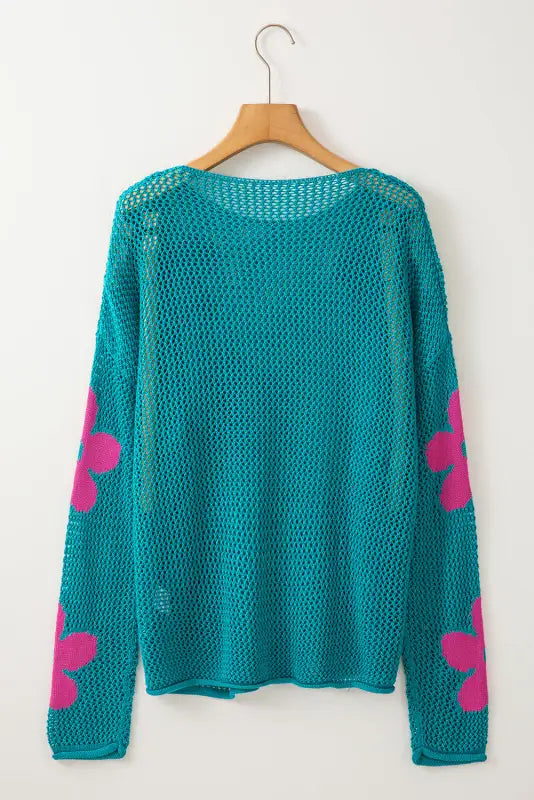 Sea green hollowed knit sweater with pink butterfly sleeves on a wooden hanger