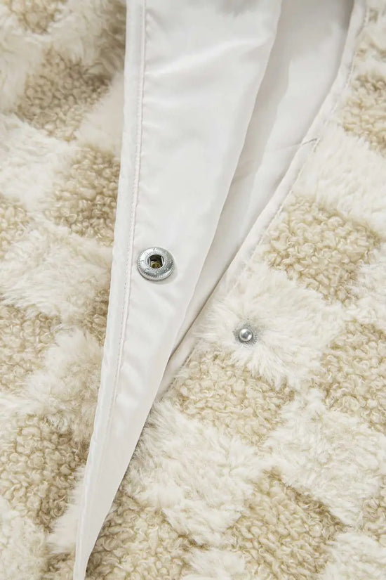 Close-up of a textured fabric with a button and white lining.