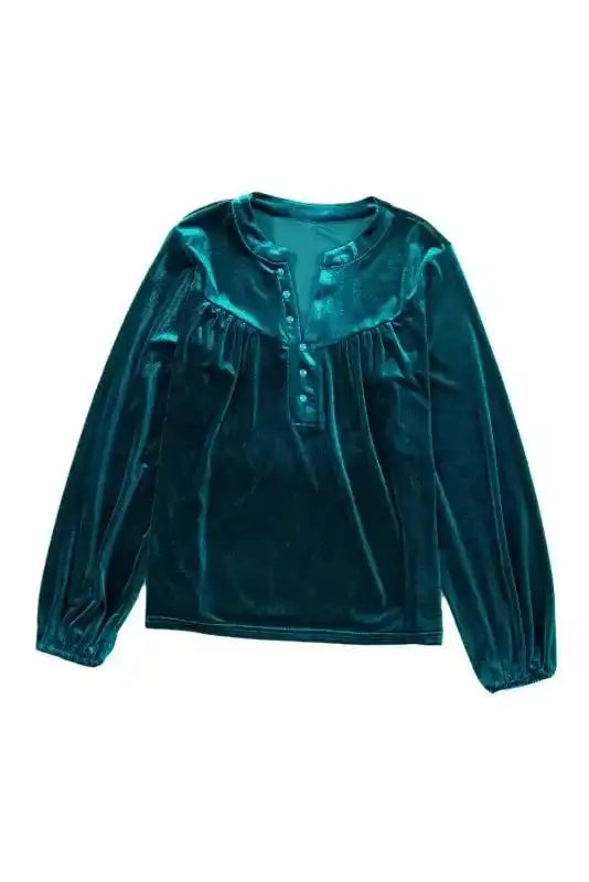 Full view of Skobeloff velvet blouse laid flat, showing beaded front and long sleeves in rich green velvet.