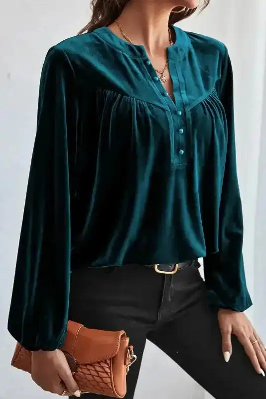 Elegant Skobeloff velvet blouse paired with black pants and a clutch, showcasing its cozy and sophisticated design.