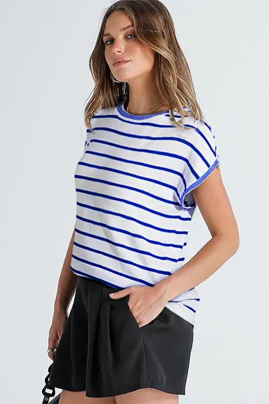 Woman relaxing in a sky blue stripe t-shirt and black shorts, showcasing casual chic style