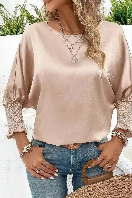 Dolman Sleeve Satin Blouse in smoke gray with shirred cuffs, styled with layered necklaces and denim for an elegant casual look.