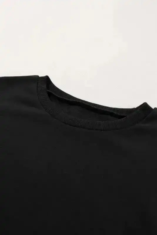 Close-up of crew neckline on Black Snap Button Pullover, showing ribbed trim and soft fabric texture for everyday wear.