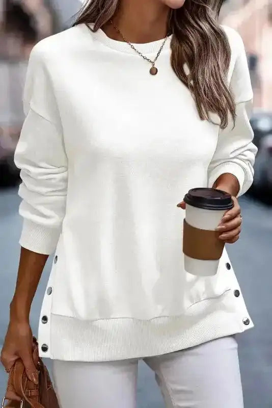 White Snap Button Pullover styled with coffee cup and white pants, featuring side splits for a trendy casual vibe.
