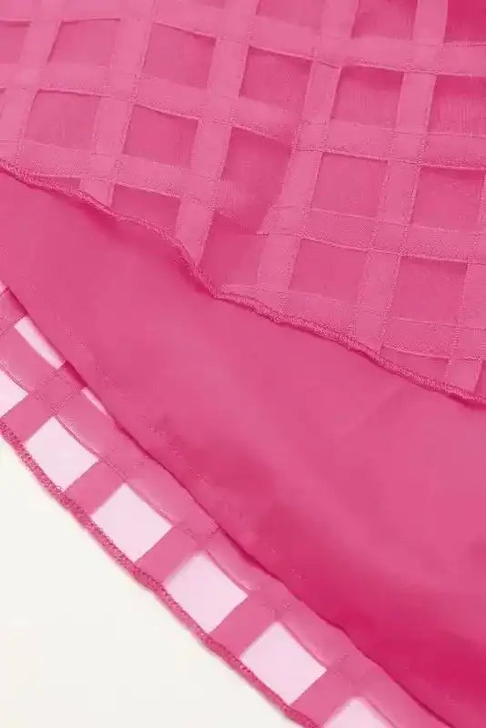 Layered hem detail of strawberry pink checkered babydoll dress, showing sheer overlay and solid lining for added comfort and style.