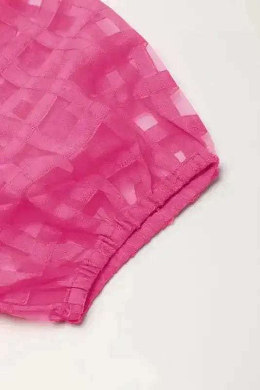 Close-up of puff sleeve with elastic cuff on strawberry pink checkered babydoll dress, emphasizing feminine and airy design.