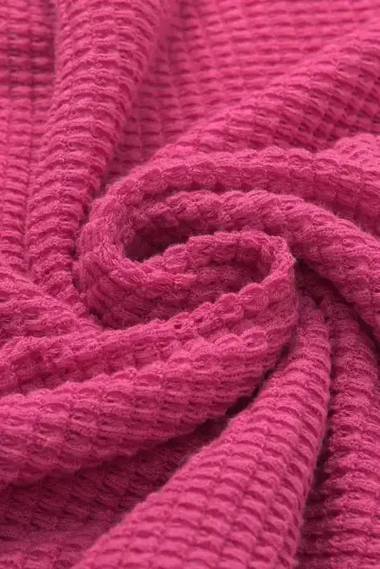 Close-up of waffle knit fabric in Strawberry Pink Knit Split‑Neck Top, showing textured detail and soft material for breathable comfort.