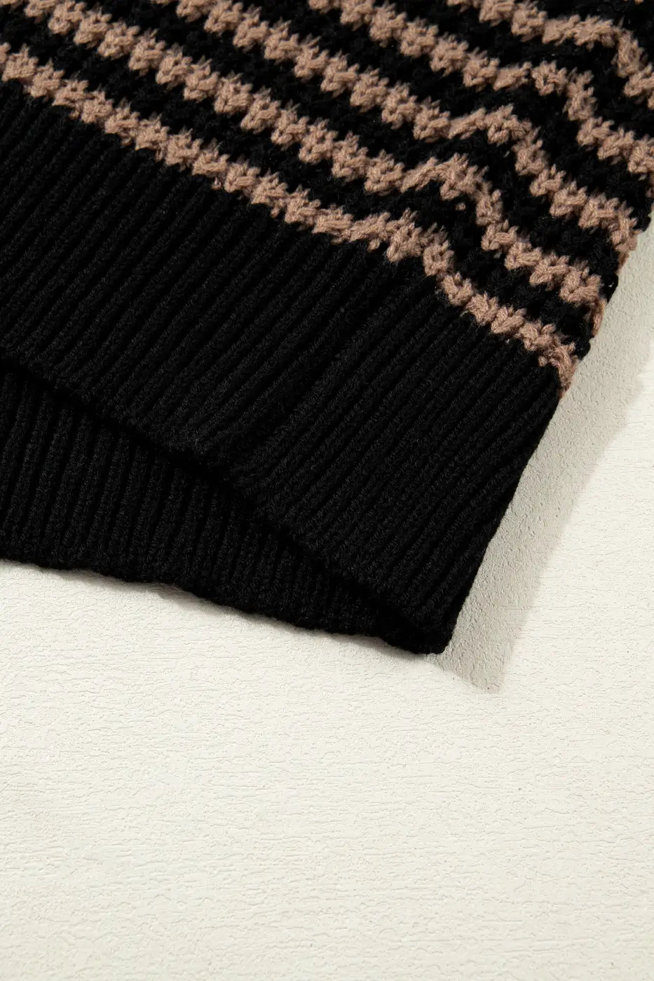 Bottom hem detail of black and taupe striped soft-knit slouchy jumper. Ribbed edge adds structure to this relaxed fit summer sweater.