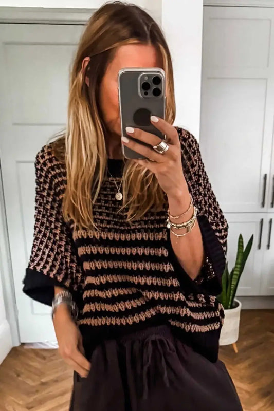 Black and taupe striped soft-knit slouchy jumper for women, styled casually with dark trousers. Cozy short sleeve sweater for daily wear.
