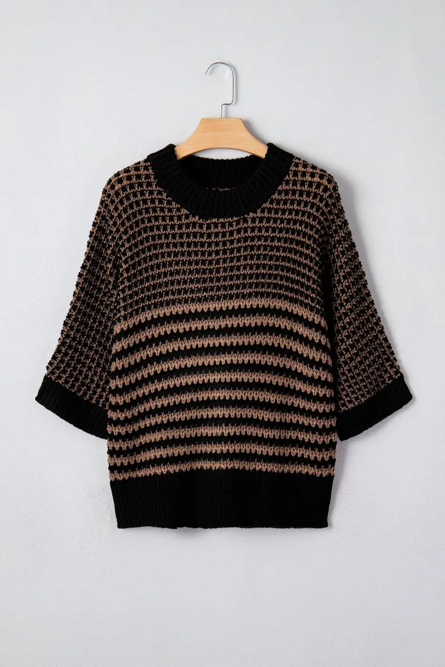 Front view of black and taupe striped soft-knit slouchy jumper on hanger. Short sleeve sweater with ribbed collar and relaxed silhouette.