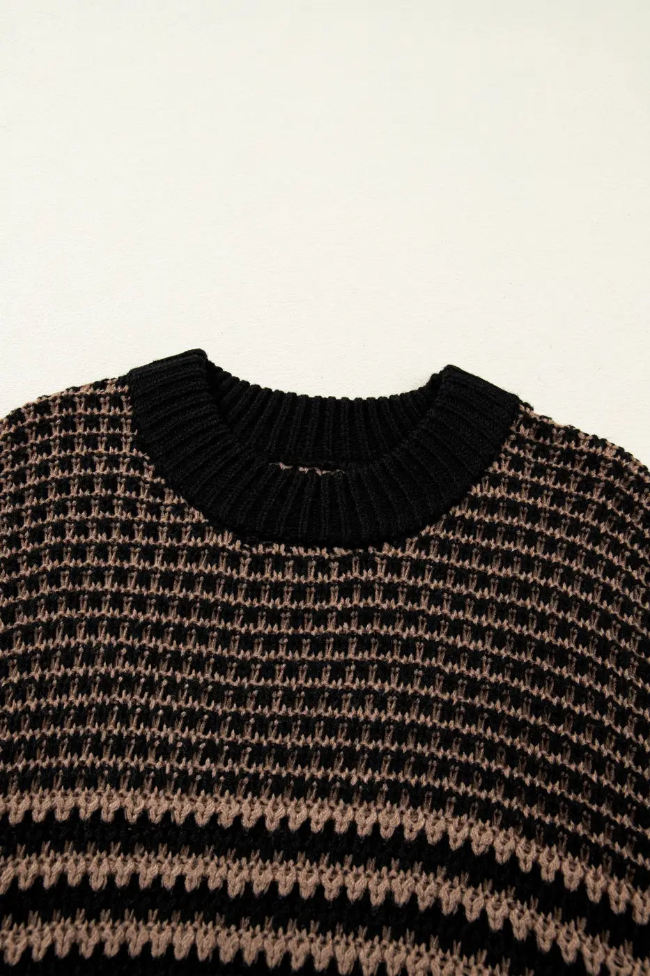 Close-up of ribbed neckline on black and taupe striped soft-knit slouchy jumper. Comfortable and stylish short sleeve sweater for women.