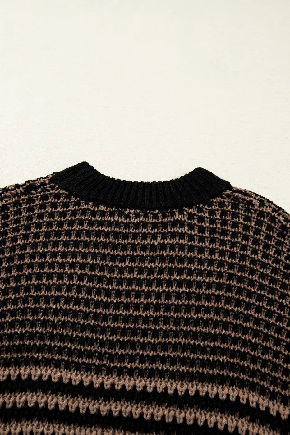 Back neckline detail of black and taupe striped soft-knit slouchy jumper. Features ribbed collar and breathable knit for summer comfort.