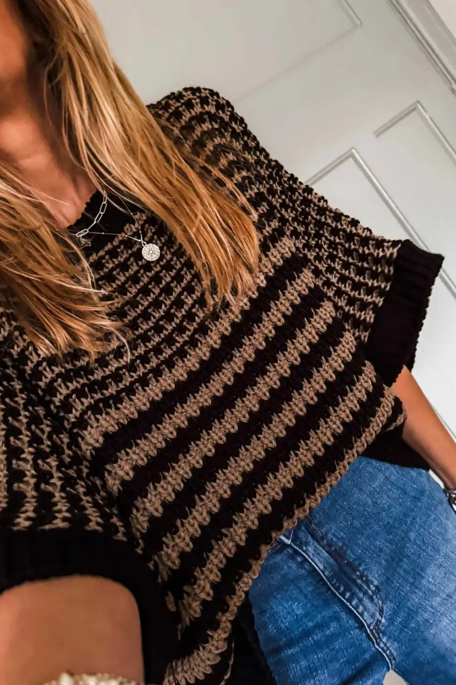 Close-up of striped soft-knit slouchy jumper in black and taupe, showing texture and short sleeves. A breathable summer knit top for women.