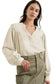 Woman in stylish notched v-neck blouse with billowy sleeves and olive green cargo pants