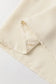 Stylish notched v-neck blouse with cream-colored fabric and detailed edge stitching visible