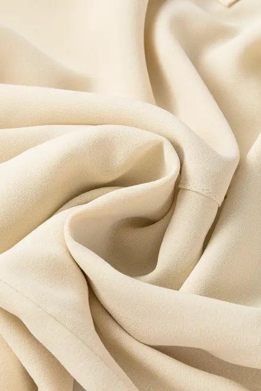 Soft creamy fabric with gentle folds in a stylish notched v-neck blouse