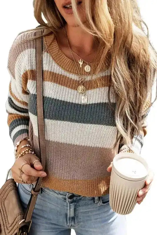 Taupe round neck knit sweater with colorblock stripes in warm tones, styled with casual denim and accessories for a chic autumn look.