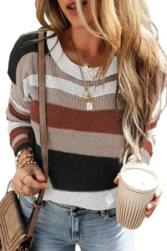 Front view of taupe colorblock knit sweater with round neckline and soft textured fabric, styled with layered necklaces and light denim jeans.