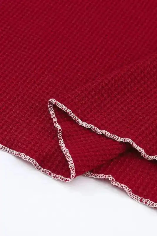 Hem detail of red Round Neck Textured Top with visible overlock stitching and soft knit texture, enhancing its casual appeal.