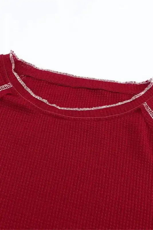 Close-up of neckline on red Round Neck Textured Top highlighting contrast stitching and soft waffle knit fabric for added comfort.