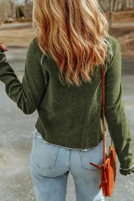 Back view of green Round Neck Textured Top styled with light denim, highlighting the top's casual cut and soft waffle knit fabric.