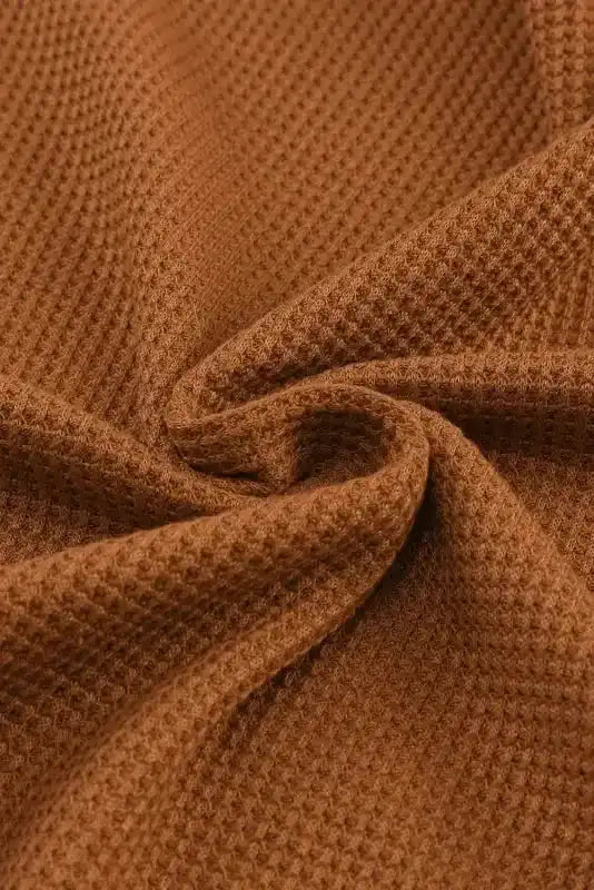 Close-up of apricot pink waffle knit fabric from the Round Neck Textured Top, showcasing its cozy texture and soft material.