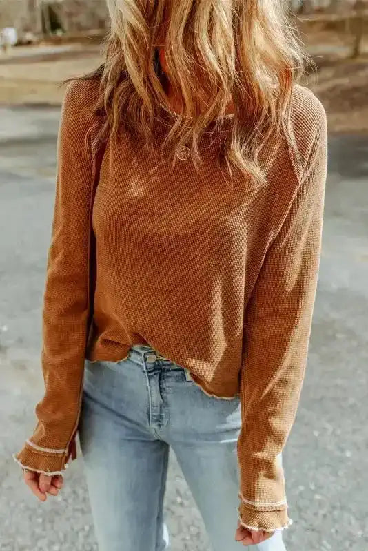 Brown textured round neck long sleeve top styled with jeans, offering a warm and earthy tone for fall fashion.
