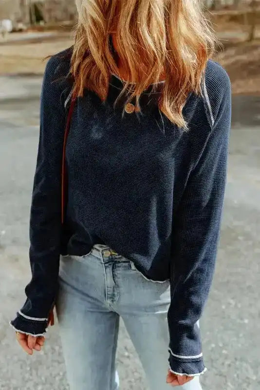 Navy blue Round Neck Textured Top styled with light wash jeans, highlighting its relaxed fit and contrast seam details.