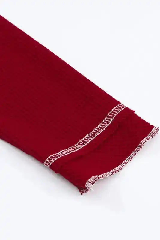 Detail of sleeve hem on red Round Neck Textured Top showing raw edge finish and textured knit for a relaxed, boho-inspired style.