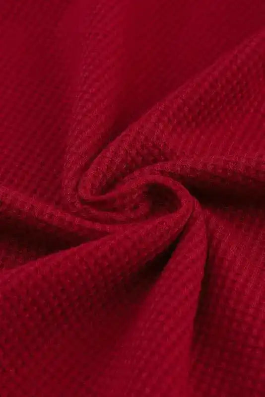 Fabric close-up of red Round Neck Textured Top displaying waffle knit texture, ideal for cozy and breathable wear in fall and winter.