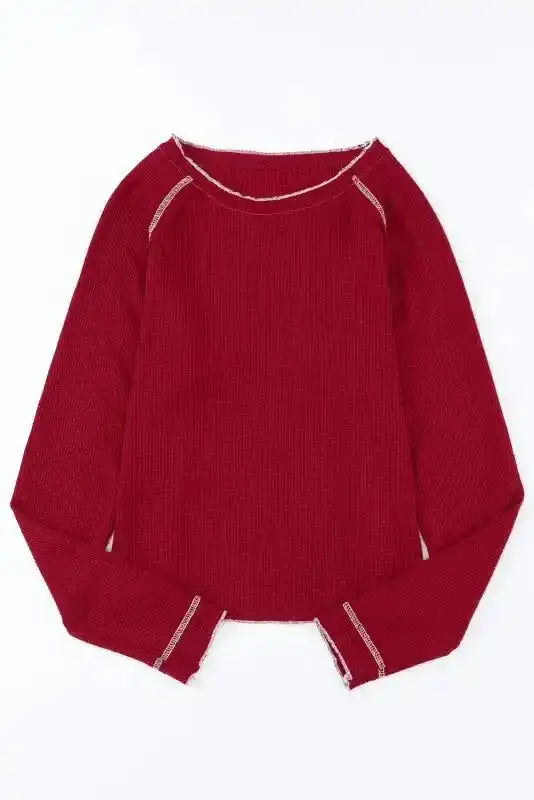 Flat lay of red Round Neck Textured Top showcasing long sleeves and raw edge hem, ideal for versatile daily wear in cooler seasons.