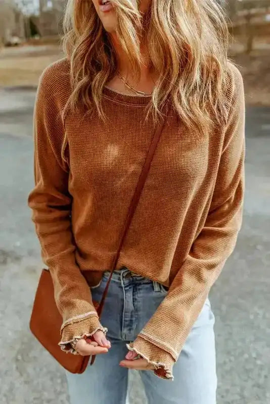 Brown round neck textured top paired with light denim jeans and a crossbody bag, ideal for everyday autumn wear.