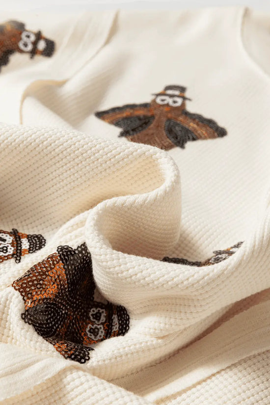 Close-up of a textured fabric Thanksgiving Oversized Knit Top.