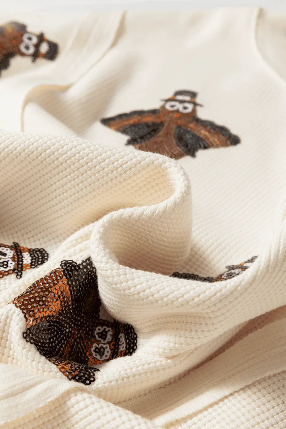 Close-up of a textured fabric Thanksgiving Oversized Knit Top.