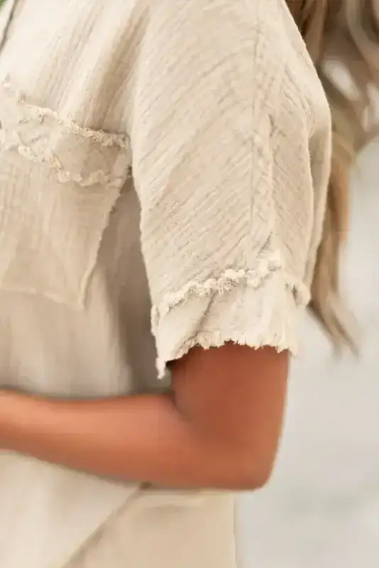 Close-up of Crinkle Frayed Tunic Top sleeve detail showing frayed trim and textured cotton fabric.