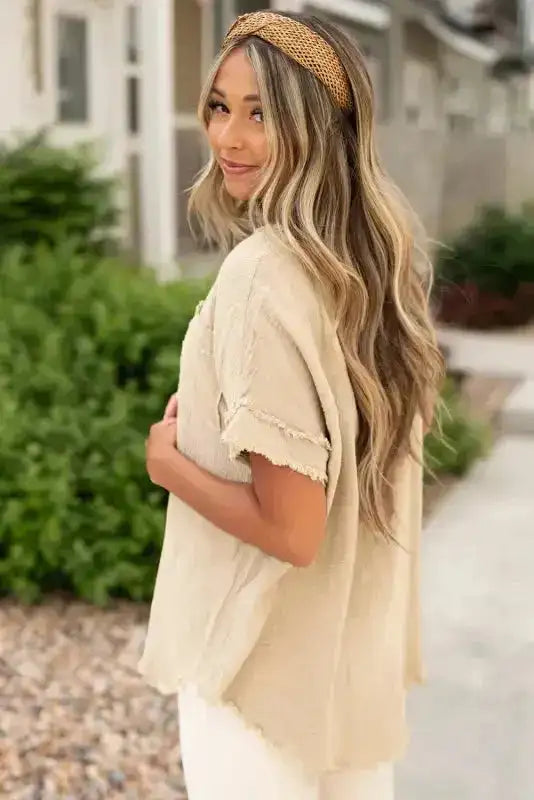 Side angle of Crinkle Frayed Tunic Top highlighting short sleeves with frayed edges and textured fabric.