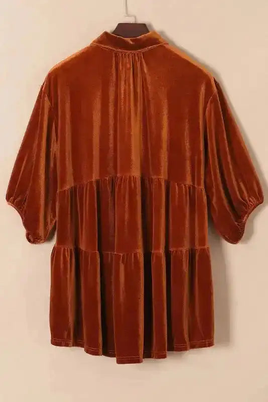 Back view of rust Velvet Babydoll Tunic on hanger highlighting tiered design and relaxed fit, ideal for fall fashion.