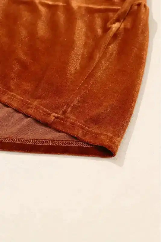 Hemline view of the Velvet Babydoll Tunic in rust, showing inner lining and high-quality stitching for a polished finish.