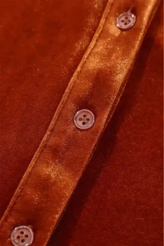 Detail of front buttons on the Velvet Babydoll Tunic, highlighting the rich sheen and smooth finish of the rust-colored velvet fabric.