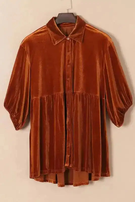 Flat lay of rust orange Velvet Tunic Babydoll Shirt on hanger, showcasing soft velvet fabric and button-down front.