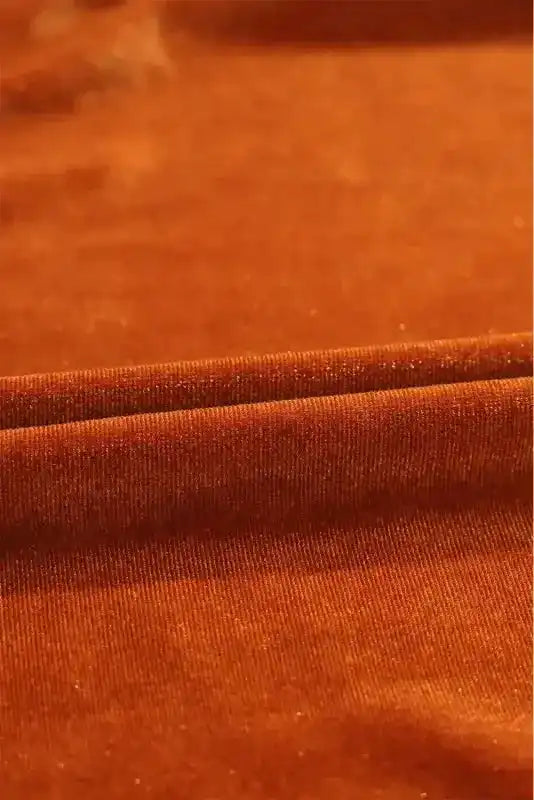 Fabric close-up of the Shop Velvet Tunic Babydoll Shirt, displaying the plush velvet texture and warm rust color.