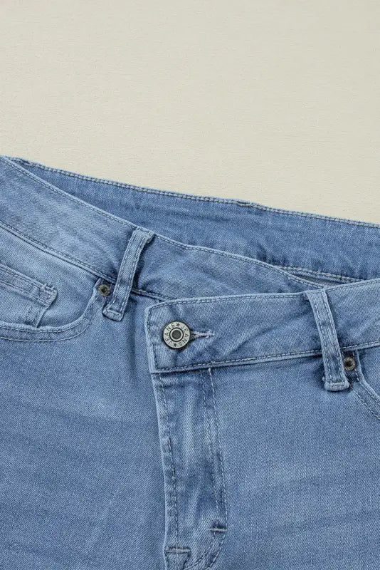 Urban edge asymmetrix jeans: light blue denim, waistband, and pocket detail