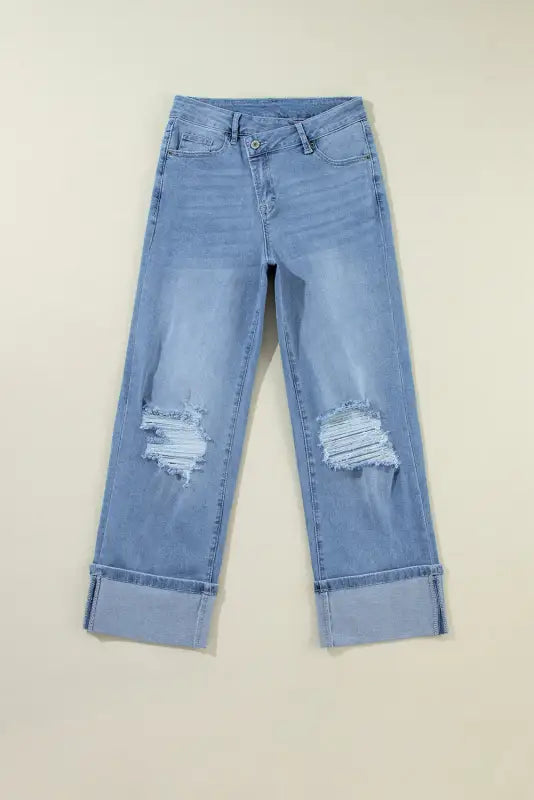 Urban edge asymmetrix: light blue distressed jeans with ripped knees and cuffed hems