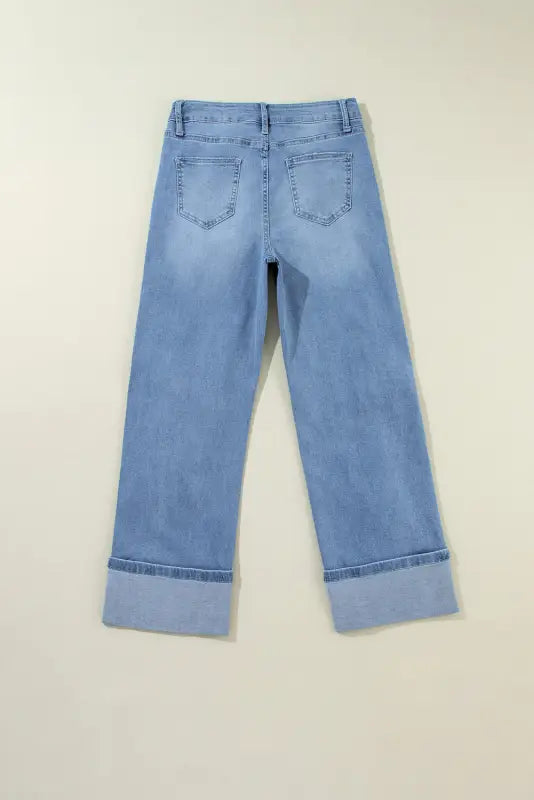 Pair of light blue urban edge asymmetrix jeans with wide cuffed hems, perfect for a relax relax style