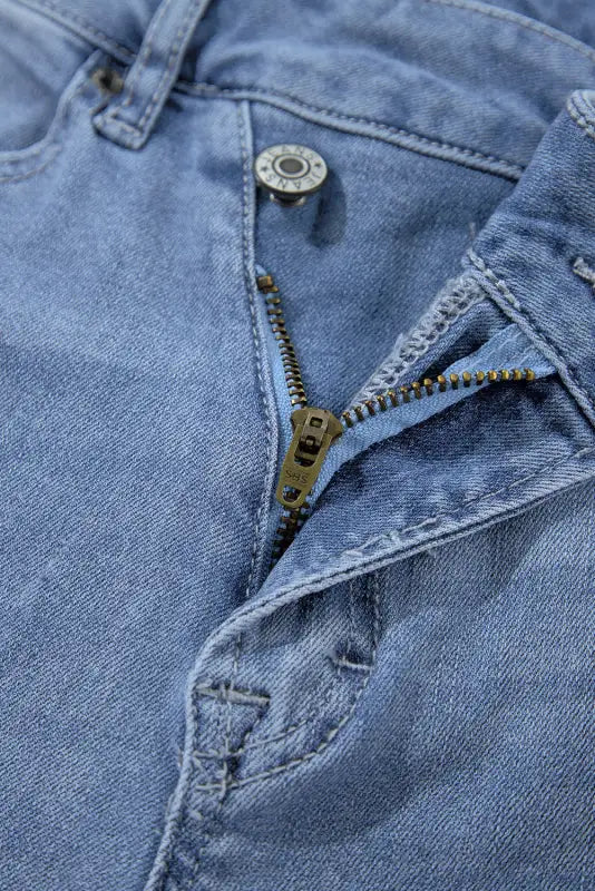 Urban edge asymmetrix jeans with a cool, partially unzipped fly in light blue denim