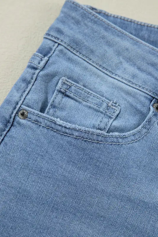 Urban edge asymmetrix jeans with light blue denim pocket, visible stitching, and coin pocket