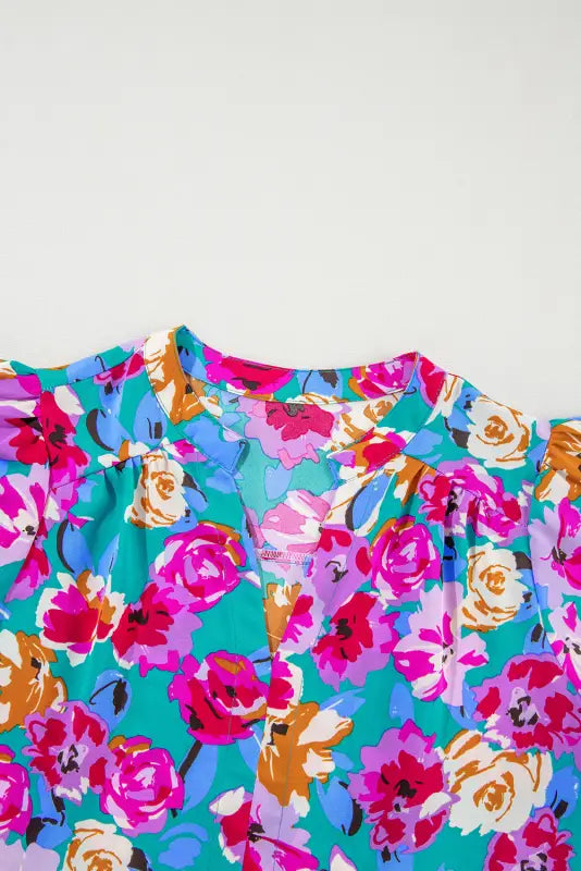 Vibrant floral print blouse in the verde flora dress with bold pink, blue, and orange flowers